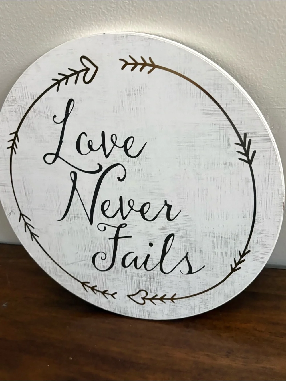 Love Never Fails Round Wall Sign - White with Black Script 12” home decor